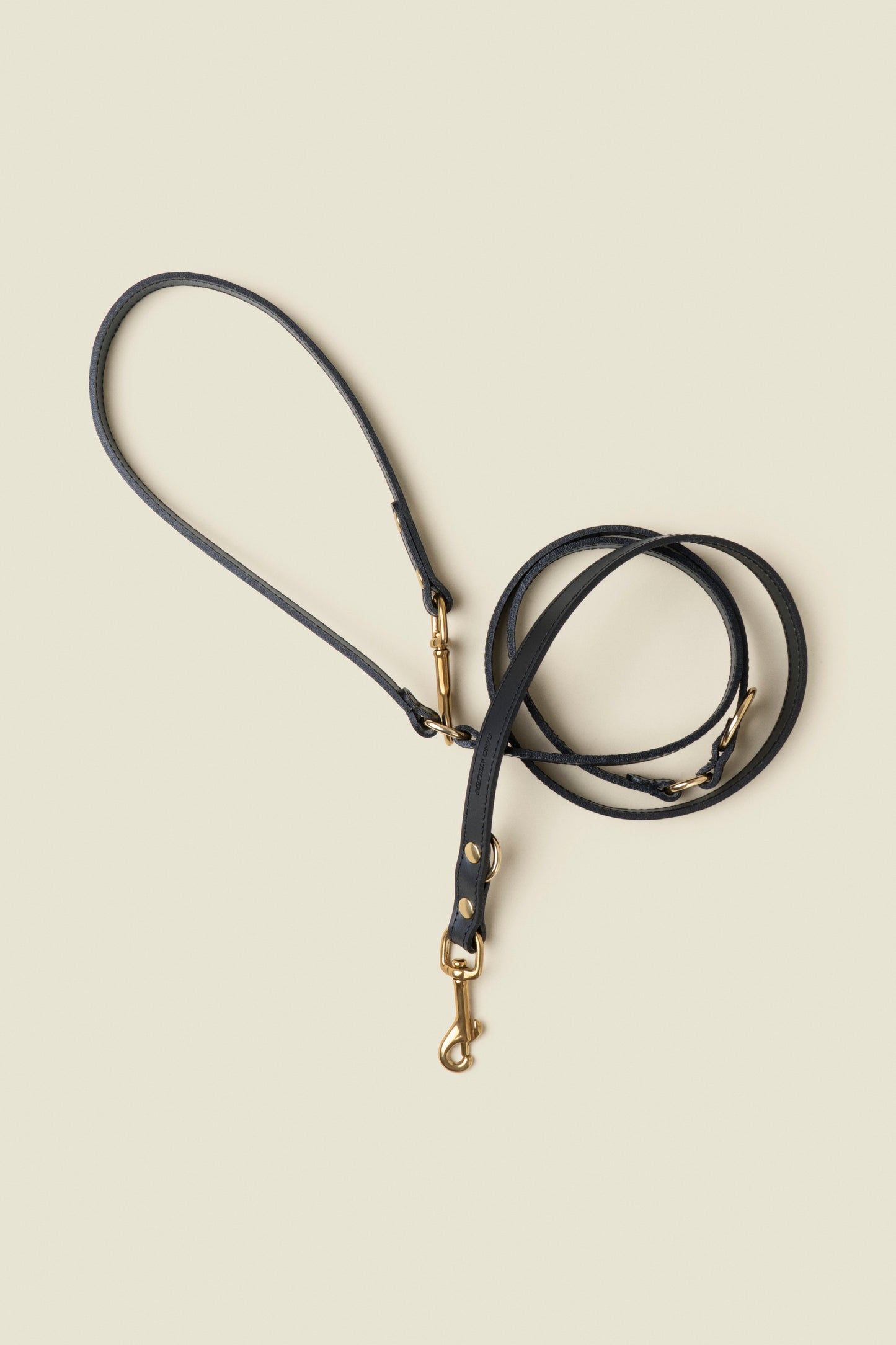 Adjustable black leather dog leash with gold hardware by Cano Ateliers